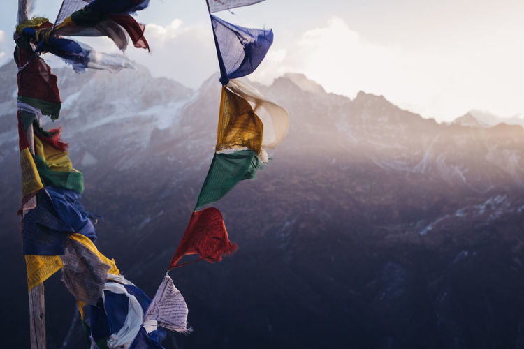 Close-up of flag on mountain range against sky