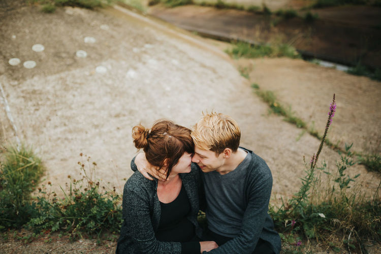 High angle view of couple embracing while sitting on land