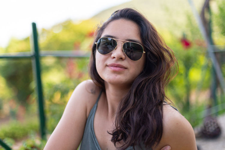 Portrait of young woman wearing sunglasses standing outdoors