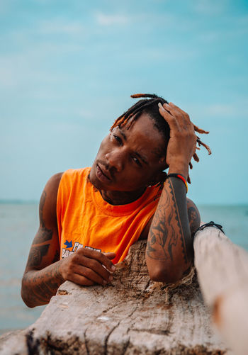 Portrait of man at beach against sky
