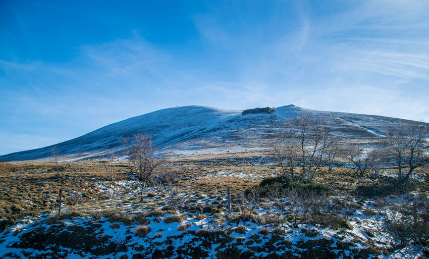 Scenic view of snowcapped mountains against blue sky