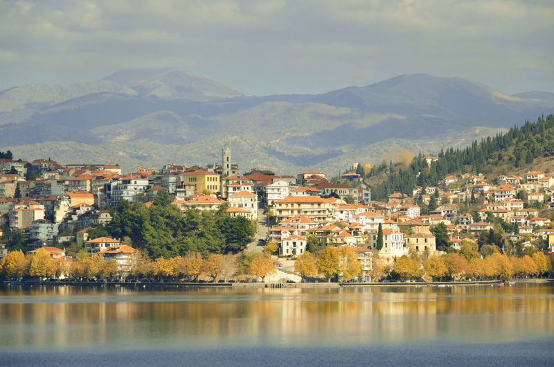 Autumn scene with  houses and trees with yellow fall leaves at the waterfront of lake kastoria