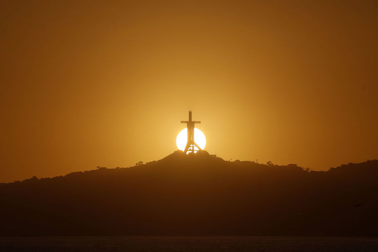 Silhouette of communications tower during sunset