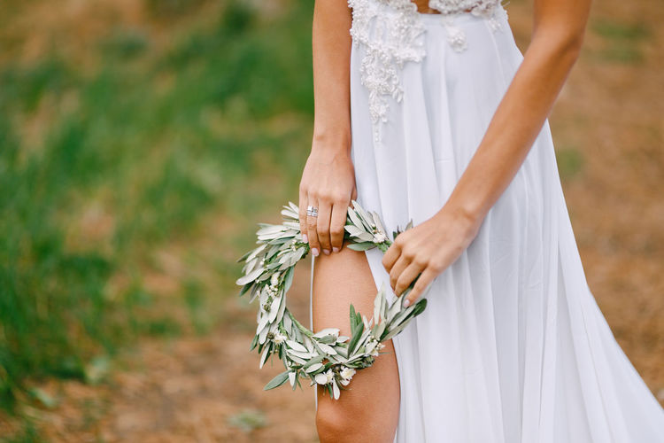 Midsection of woman standing while holding tiara