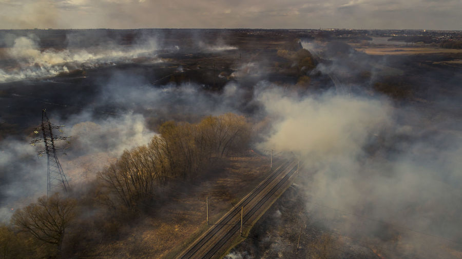 Massive fire, dry grass lanes in fire, firefighters at work, disaster, ecological catastrophe