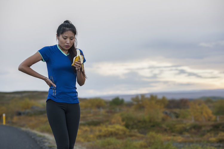 Beautiful woman eating banana during work out in rural area in iceland