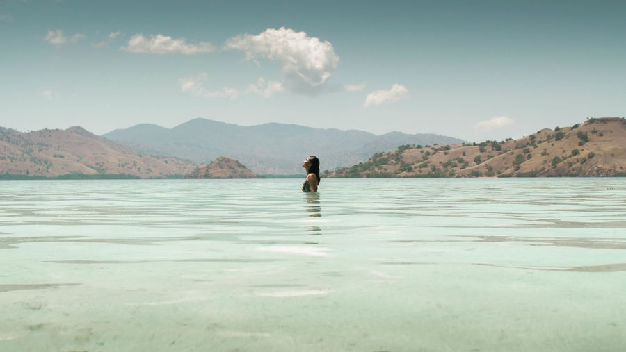 Woman swimming in sea against sky