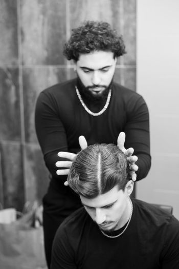 Barber adjusting hair of man at salon
