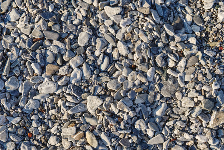 Seamless pattern of polished stones in a rocky beach