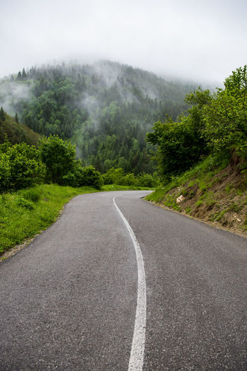 Road amidst trees against sky