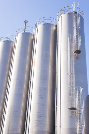 Low angle view of silos against clear sky