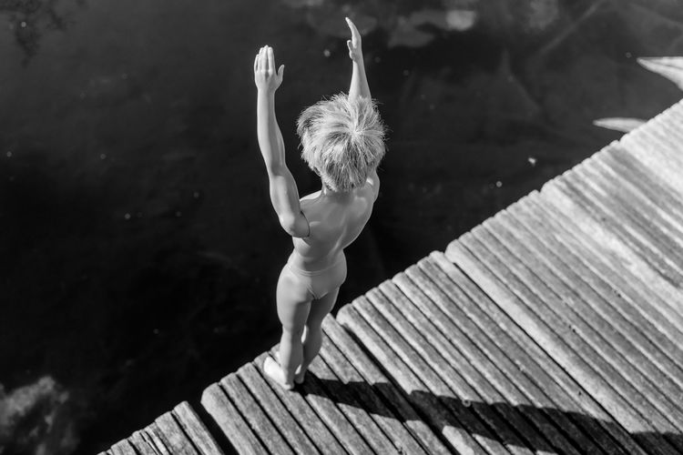 Low section of woman jumping in water
