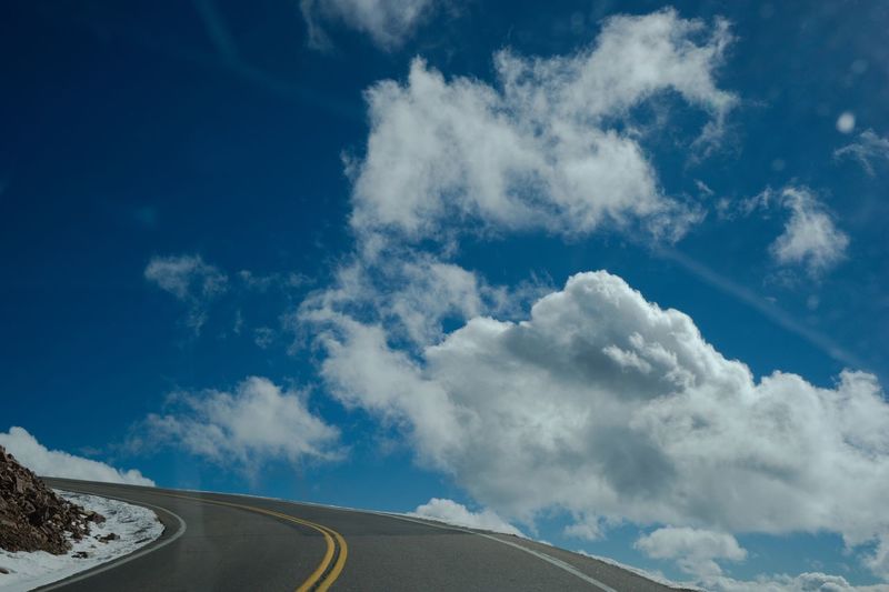 Diminishing perspective of road against blue sky