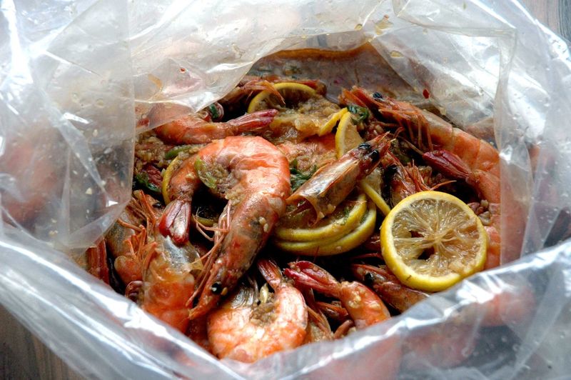 High angle view of shrimps and lemon slices in plastic bag