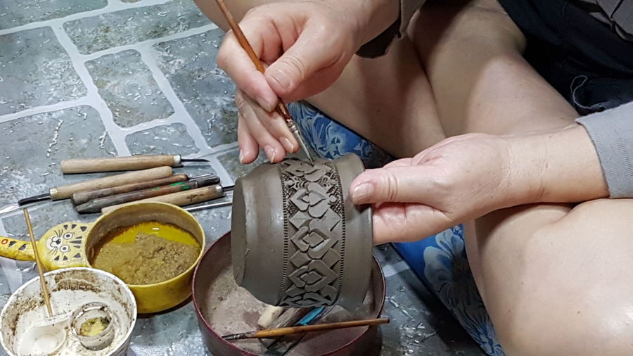 High angle view of woman decorating pottery 