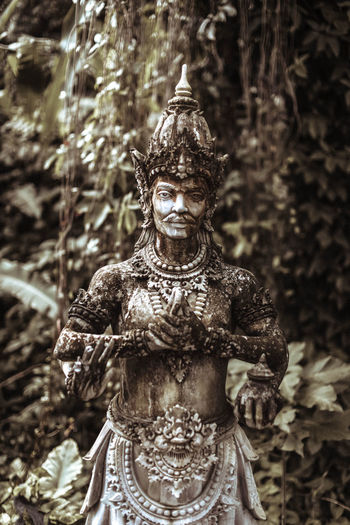Balinese statue stone figure of the god. water palace of tirta gangga in east bali, indonesia.