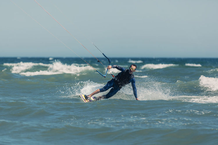 Mature man kiteboarding in sea on sunny day