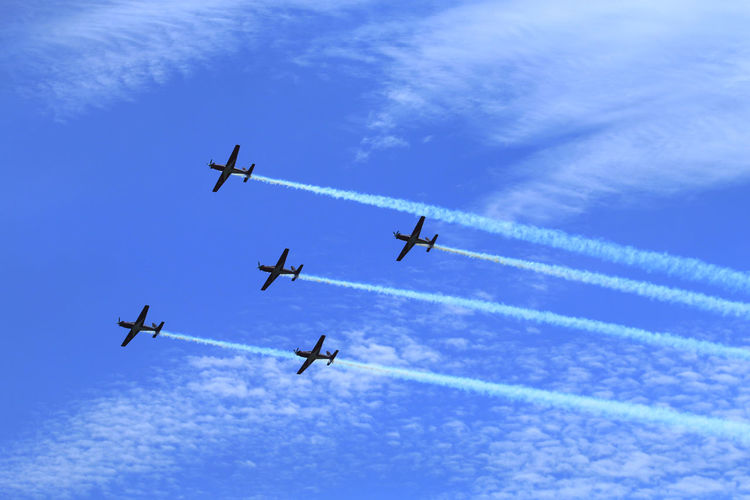 Low angle view of airplanes flying against sky
