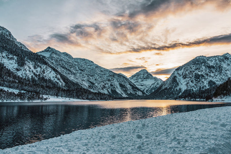 View from the uferstrasse to the plansee in tyrol, austria. romantic sunset behind the mountains.