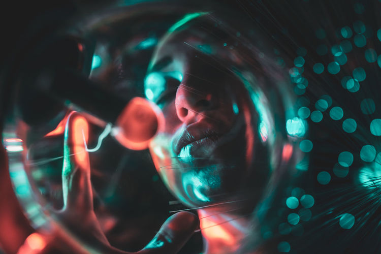 Digital composite image of woman and plasma ball with fiber optics