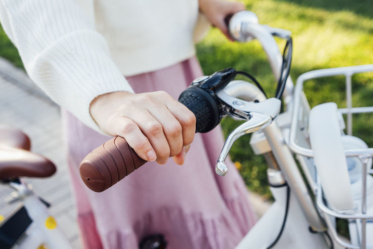 Midsection of woman holding bicycle