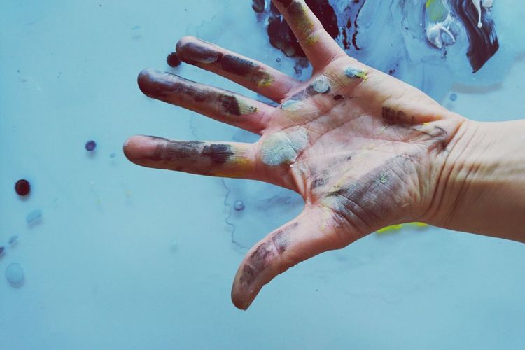 Cropped image of man with messy painted hand