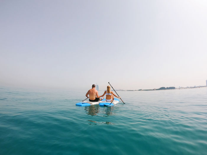 Active couple on the paddle boards with a view on burj al arab