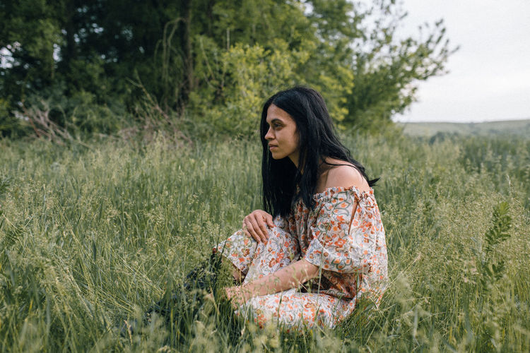 Portrait of woman alone in field thinking