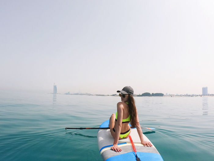 Young woman paddle boarding in dubai