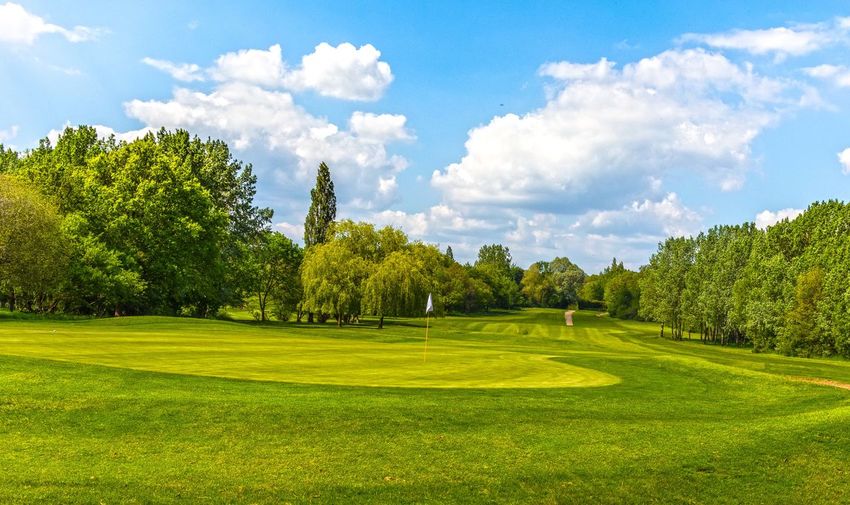 Scenic view of golf course against sky