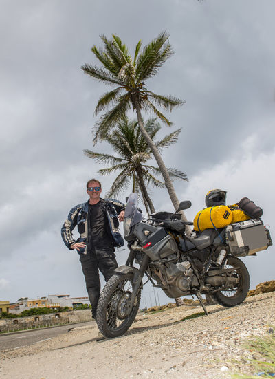 Man posing next to his adventure motorbike after a long trip, columbia