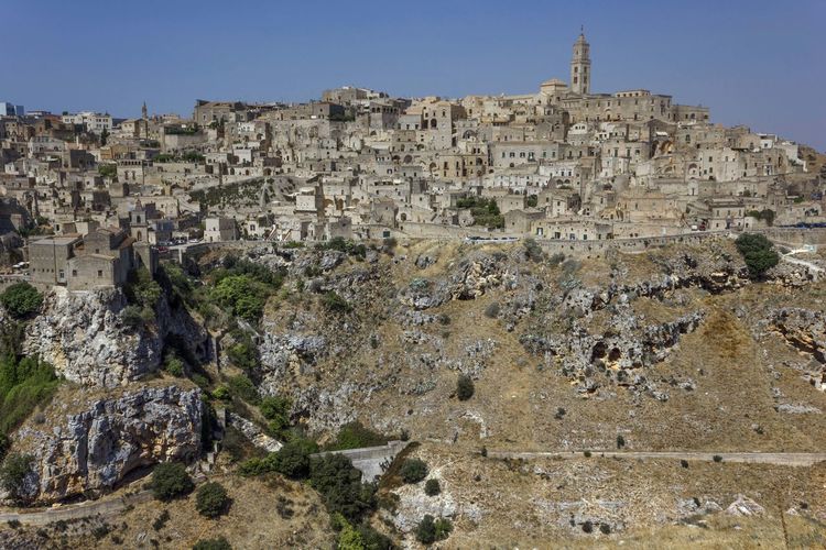 Low angle view of matera town on mountain against clear sky