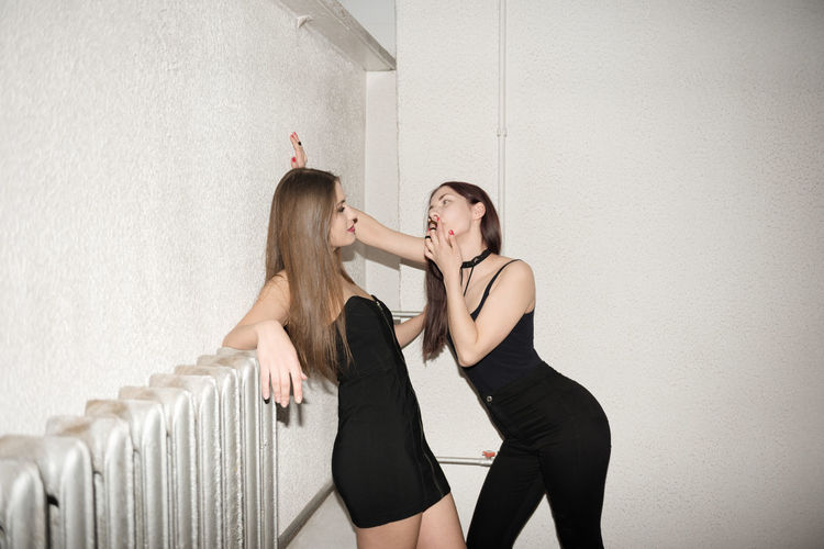 Young women against white wall