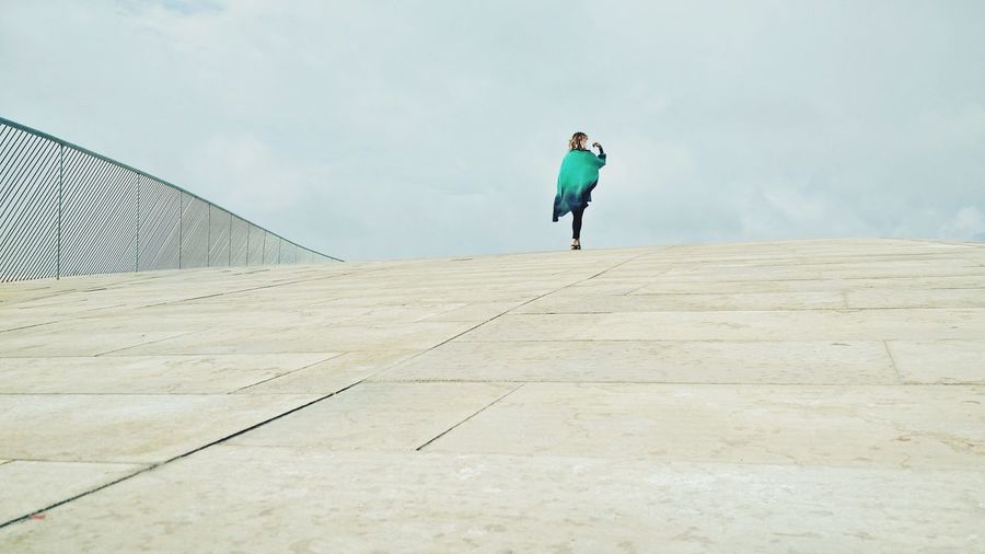 Full length of woman walking on bridge against sky