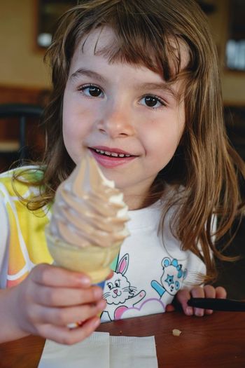 Cute girl holding ice cream at restaurant