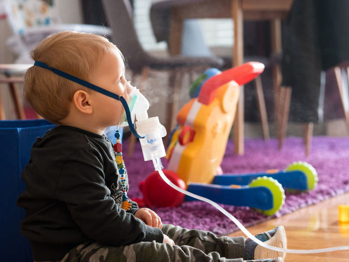 Side view of cute baby boy taking steam at home