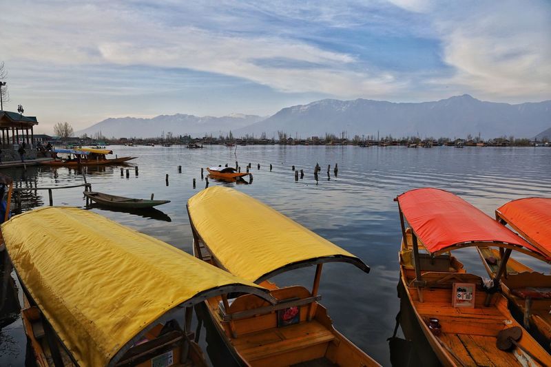 Boats moored in lake against sky, shikara at dal lake srinagar kashmir march 2021