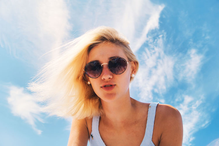 Portrait of woman wearing sunglasses against sky