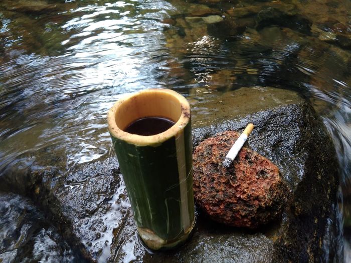 High angle view of coffee on rock by river