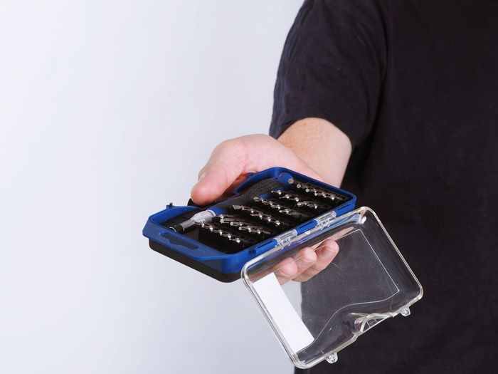 Close-up of hand holding camera over white background