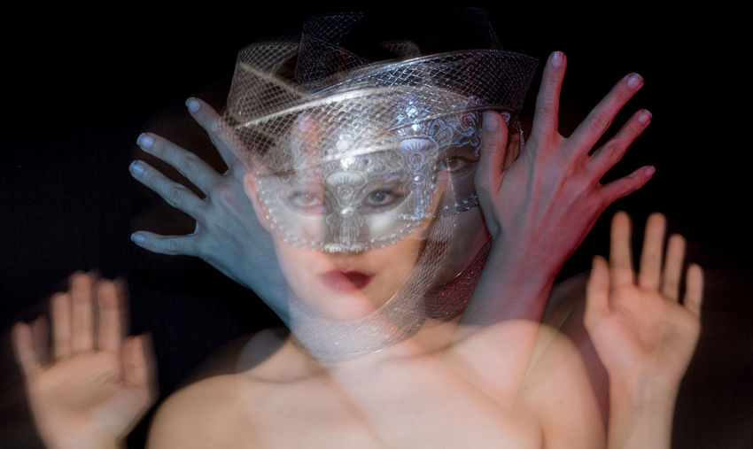 Digital composite image of woman wearing mask against black background