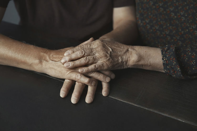 Senior couple stacking hands on table
