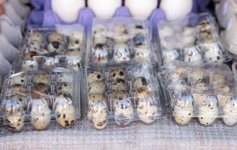 Small egg crates of speckled quail eggs at a local farmers market