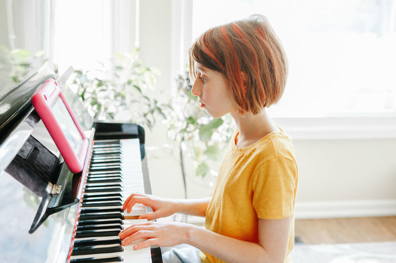 Side view of girl playing piano