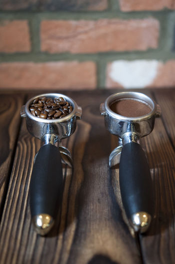 Close-up of ground coffee and roasted coffee beans in filters on table