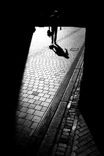 Rear view of silhouette man walking on street