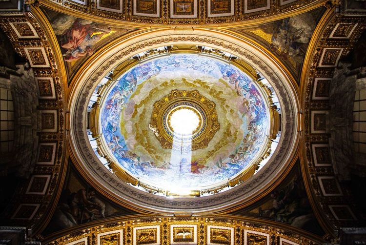 Low angle view of light beam through cathedral dome inside st. peter's basilica
