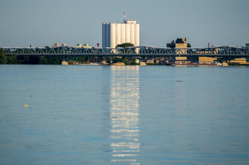 View of bridge against industrial buildings