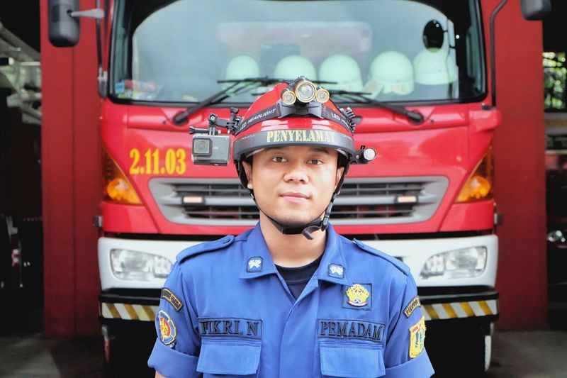 Firefighter standing in front of fire engine
