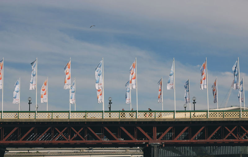 Low angle view of flags against clouds